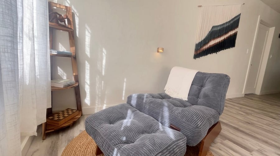 Reading lounge with a reading light mounted on the wall above.