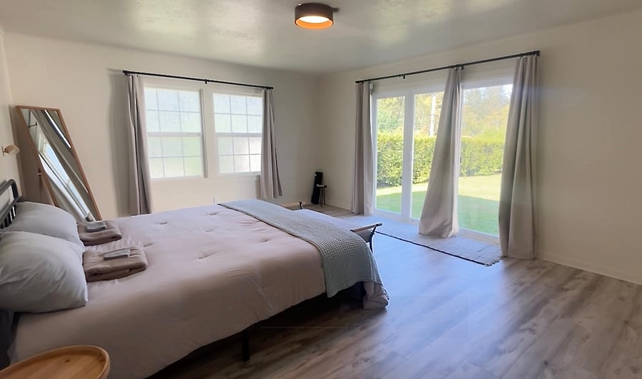 The master bedroom has a king-size bed and a direct entrance to the enclosed backyard. Also, the two large windows that face the street have a film that allows light to come in while giving you privacy.