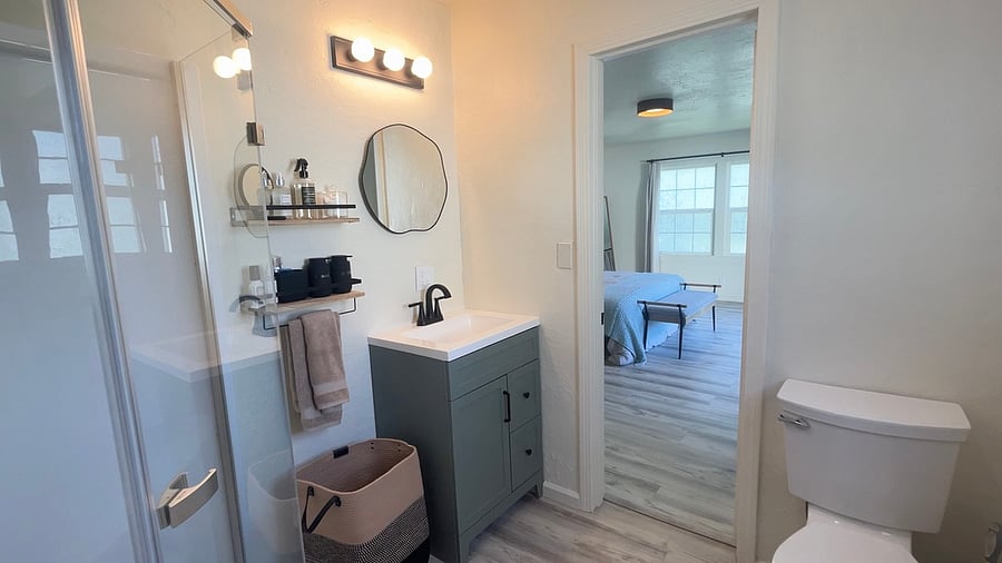 It's a small bathroom but comfortable with a shower. It connects to both bedrooms.