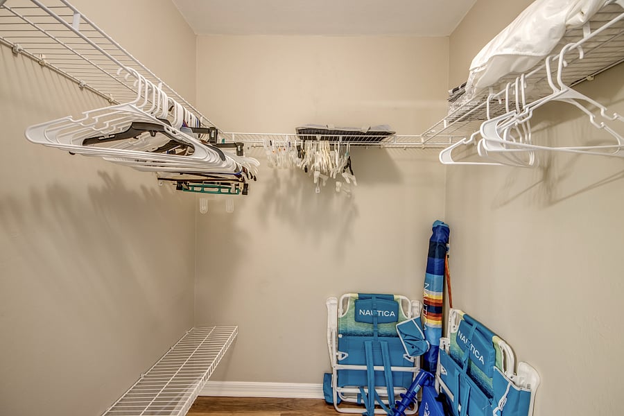 Large walk in mater bedroom closet with beach chairs and umbrella