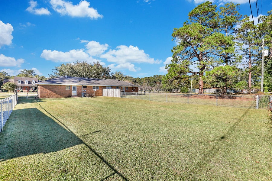 Fenced back yard with patio table and chairs.