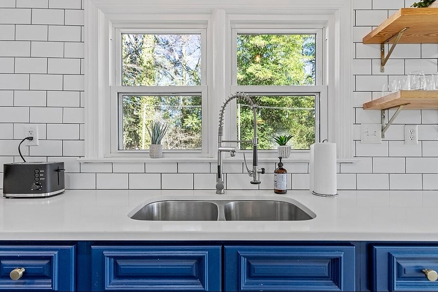 Modern and deep sink with view of wooded backyard