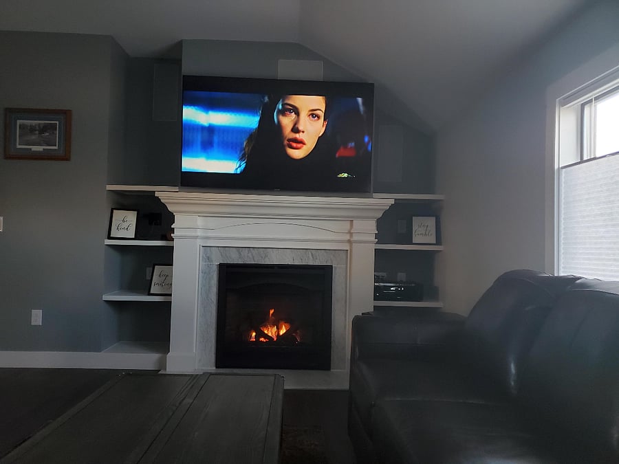 Living room fireplace and 70" Samsung smart TV with surround sound stereo.