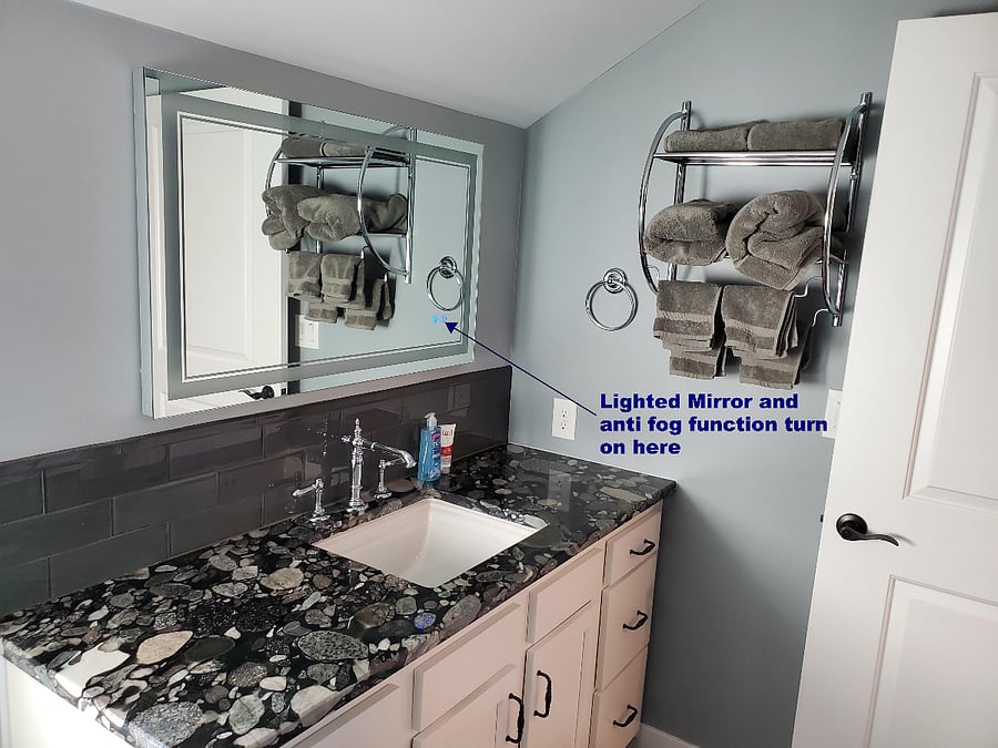 Bathroom sink and lighted and steam resistant mirror