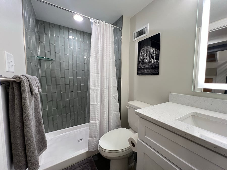 Secondary bathroom shower with rich vertical subway tile.