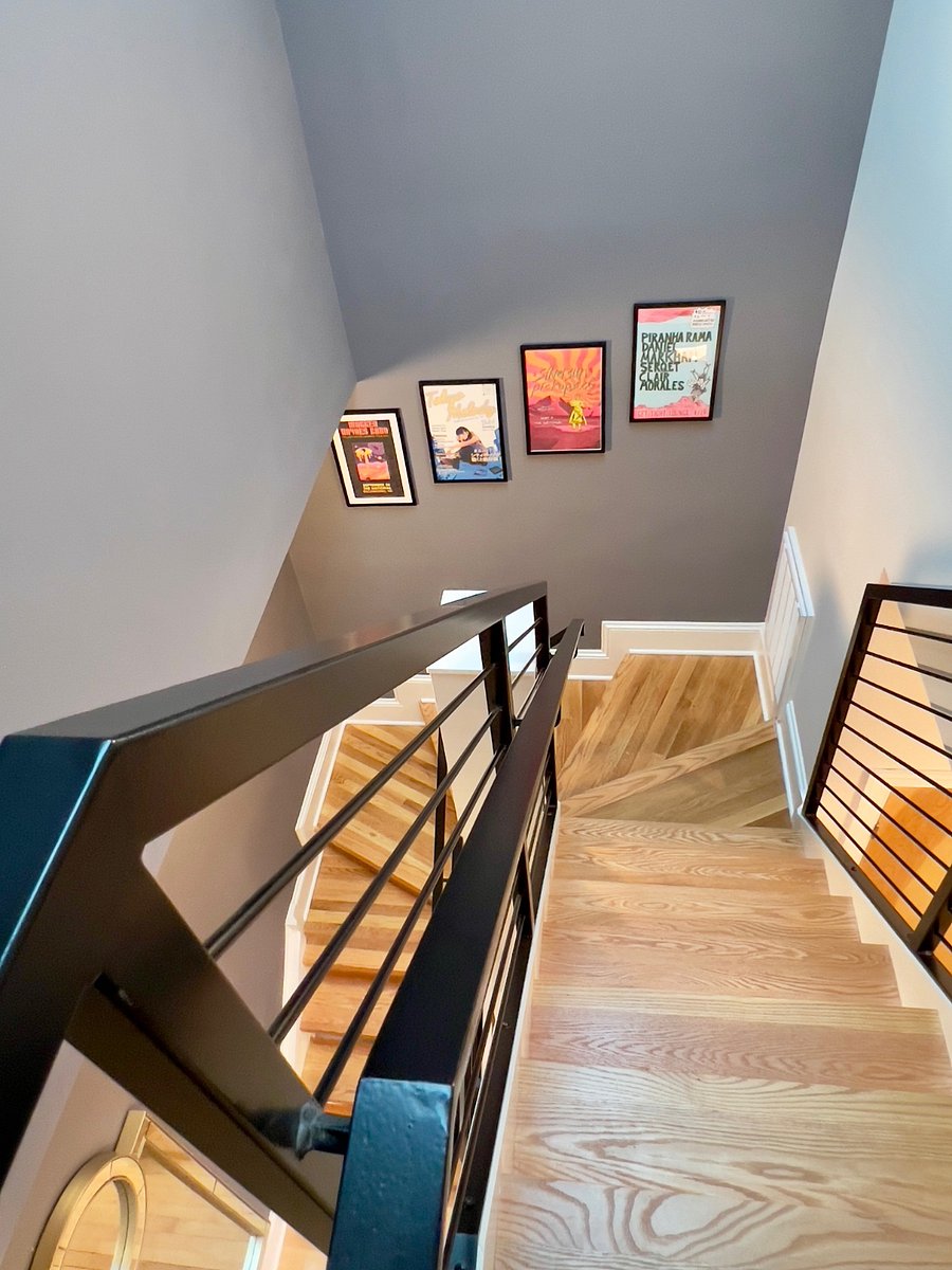 Custom staircase and handrail system leading to the main floor. Colorful artwork depicting local, recent concerts and other events.