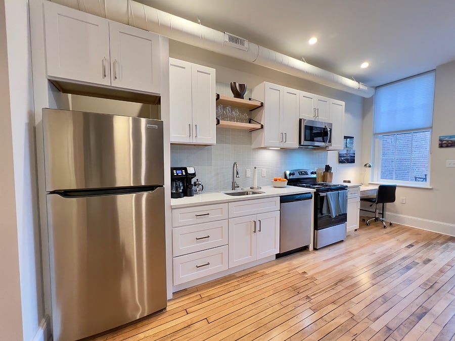 Spacious, well-stocked kitchen with wood cabinetry & soft-close drawers.