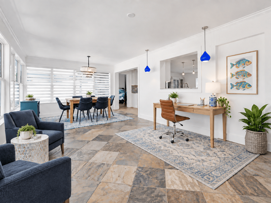 seating area, work station and dining room all in a bright and airy sunroom