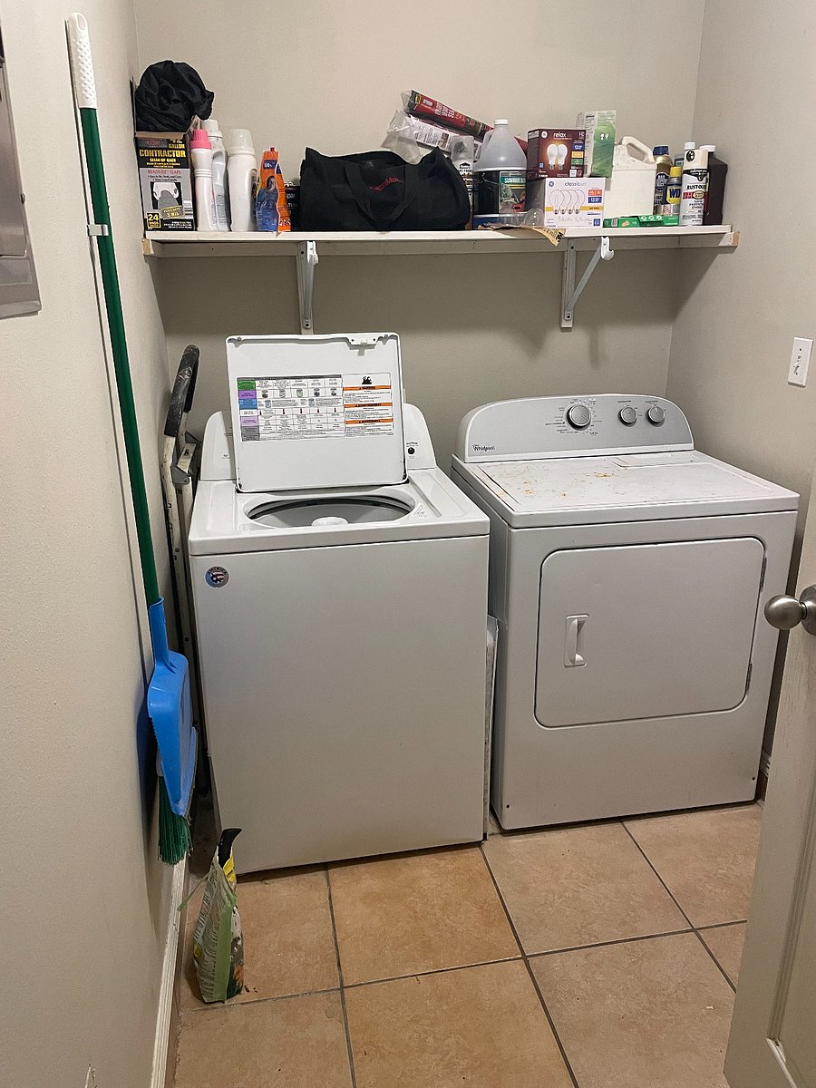 Full size washer and dryer with utility hanger for indoor broom and dust pan. Water heater on the floor behind the laundry room door.