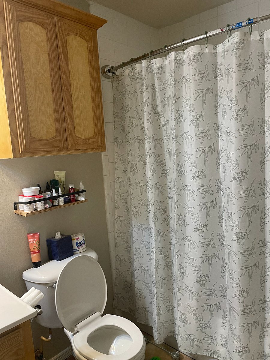 Hall bathroom with permanently mounted curtain rod with liner and curtain. Overhead and below sink storage space. Small utility shelf for cosmetics or medication.