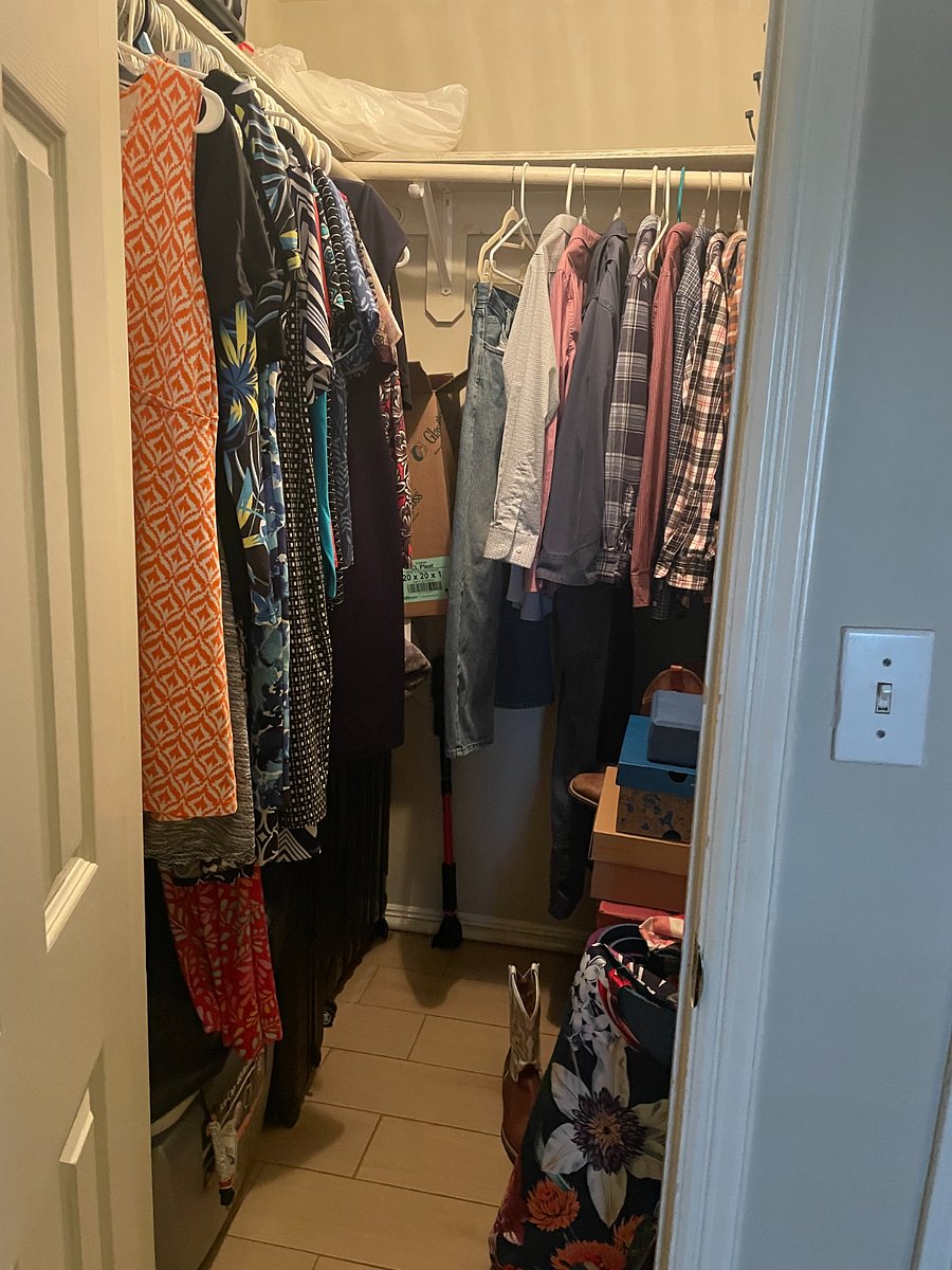 Large master bedroom walk in closet with three hanging rods for clothing and overhead shelving. Additional storage space below hanging clothes.