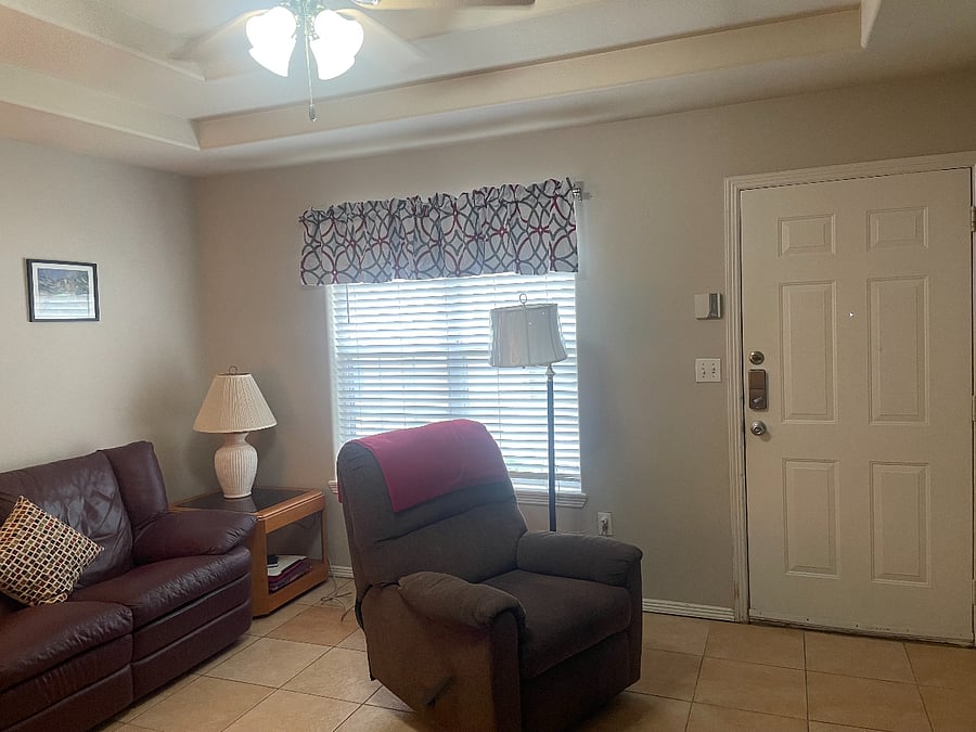 Spacious living room with ceiling fan and wide privacy blind on window. Recliner and dehumidifier available if requested.