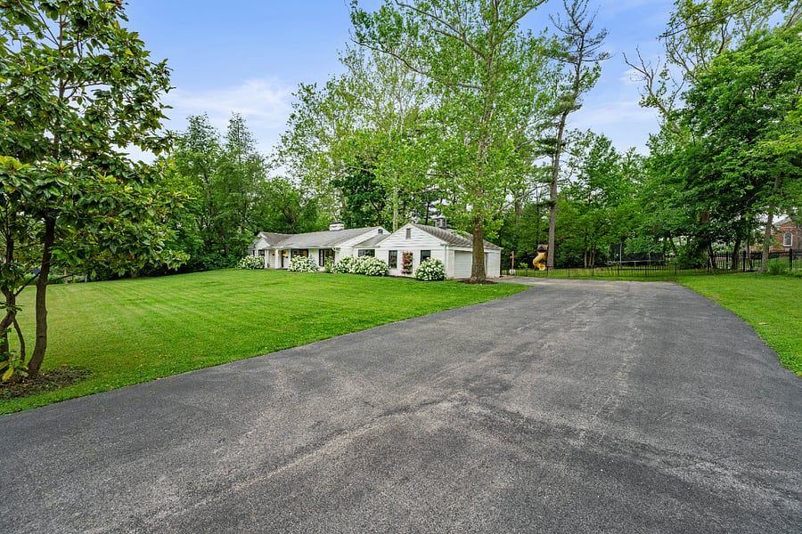 View of front of property with a side entry garage and oversized driveway with parking for 8+ cars