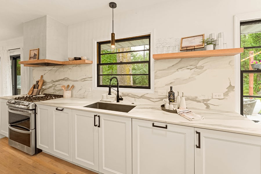 From left to right is 1. Storage cabinet 2. Gas range with a double oven and custom hood. 3. Hanging pot rack 4. Trash and recycling cabinet 5. Oversized sink 6. Concealed dishwasher 7. Storage cabinet