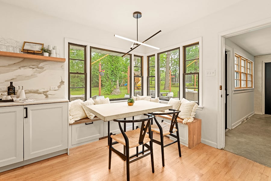 Built in breakfast nook with a custom concrete dining table and storage built into the bench with views of the backyard.
