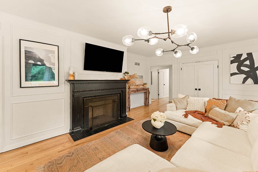 Living room with box molding, decorative fireplace (non-functional) and a wall mounted T.V.