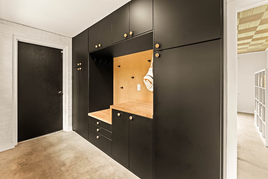 Mud room with door to the garage. The cabinetry is designed with roll out drawers to maximize storage. A built in bench is the perfect place to put on shoes with shoe storage below the seat.