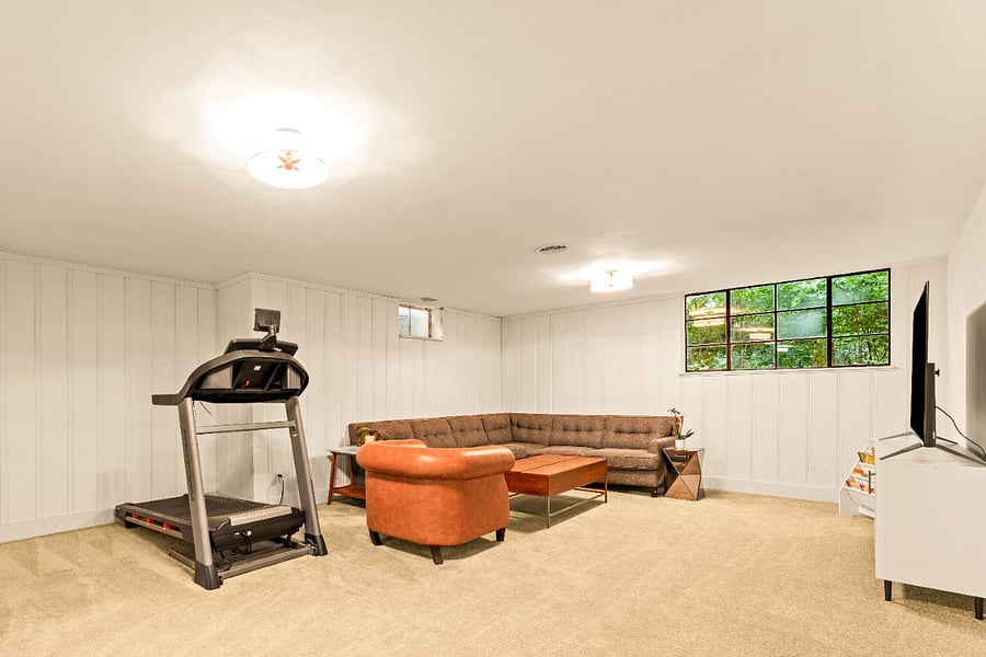 Light filled basement Rec room with a treadmill and T.V.