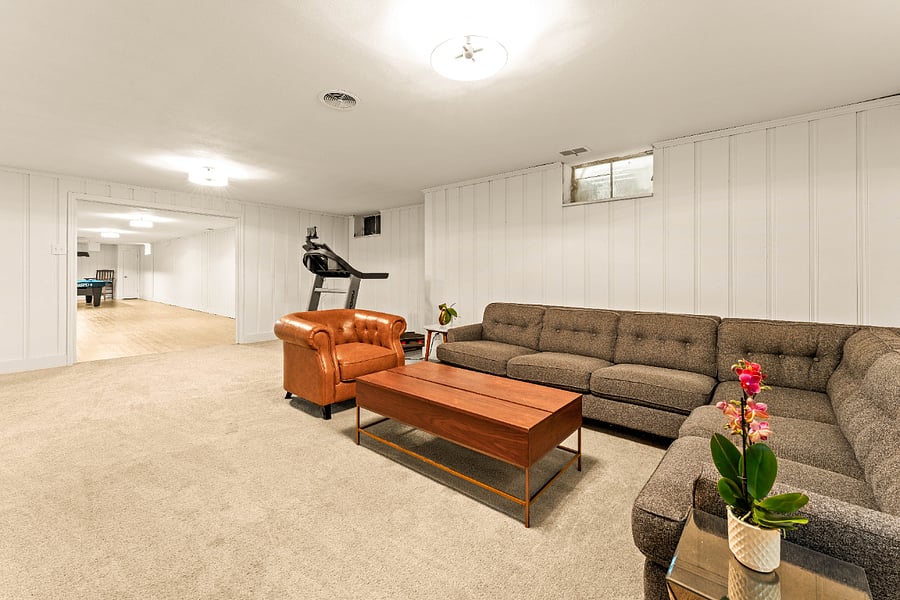 Rec room sofa, coffee table, arm chair, and treadmill.