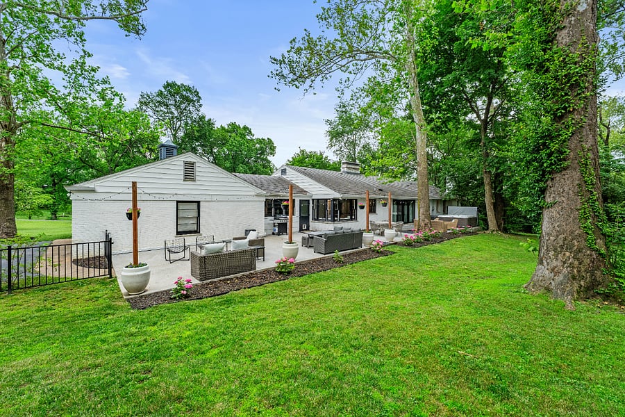 Back of house with a huge patio with ample seating space and a gas grill.
