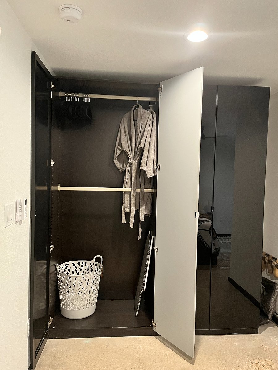 Closet has two full sides - right ride has hanging bar over three drawers. Bathrobe, laundry basket and ironing board inside.