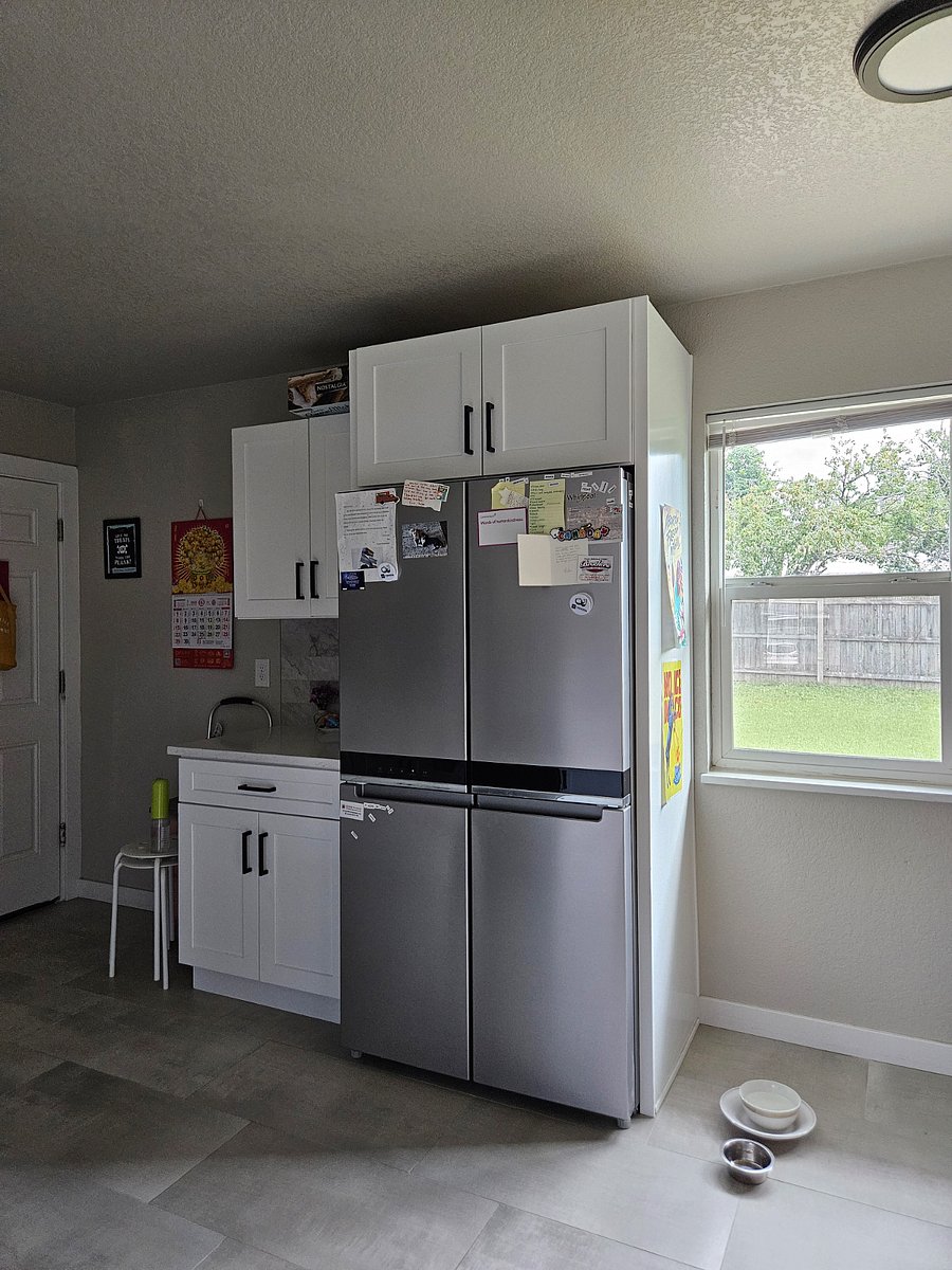 Shared kitchen space showcasing brand new stainless steel refrigerator 