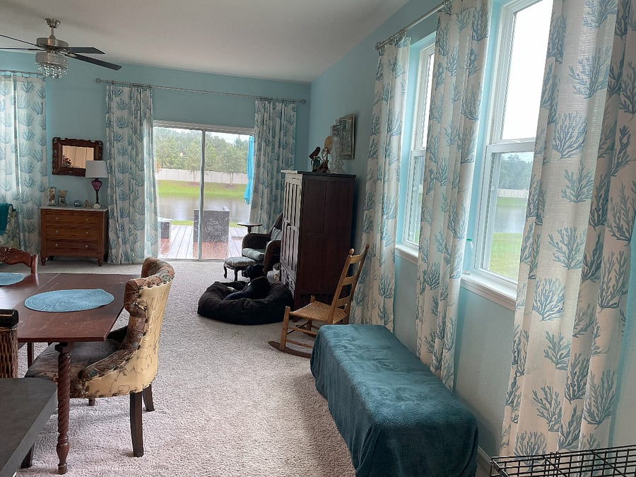 Entry into Kitchen (to left), Dining, and Living Rooms (back deck and pond visible through slider)