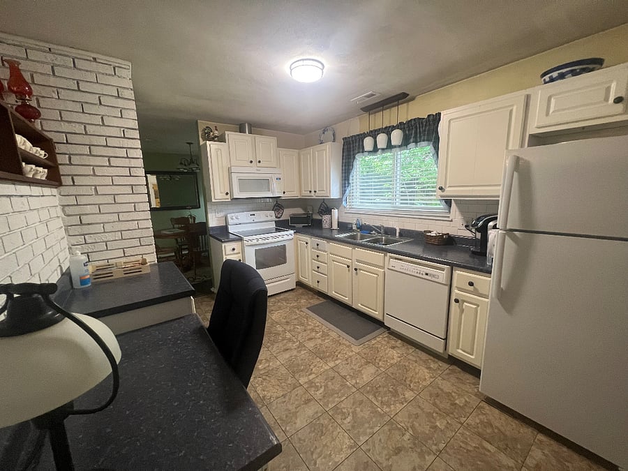 Fully equipped kitchen with desk area. We are planning to remodel the kitchen in the next year, but will work this around rentals.