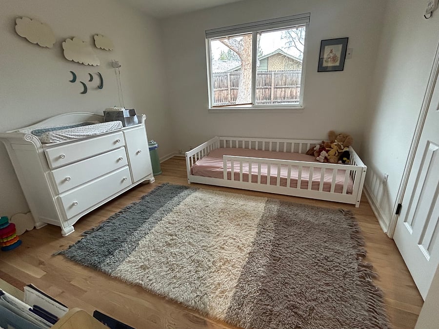 Kids room (twin bed) with dresser, baby changing station, toys, and children's books.