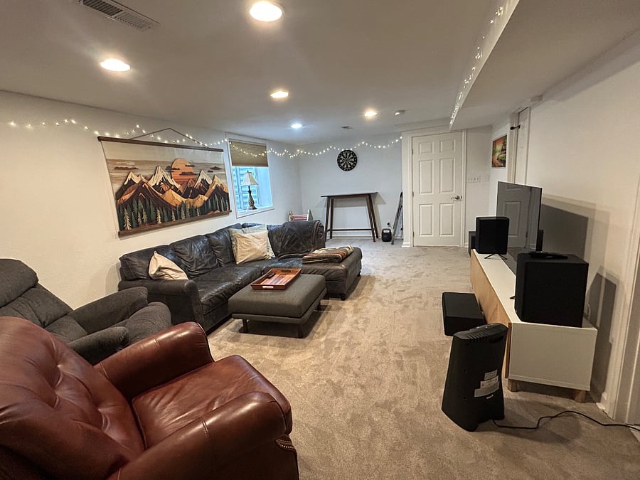Basement with smart tv, great sound system and sub, dart board, comfortable couches and chairs.