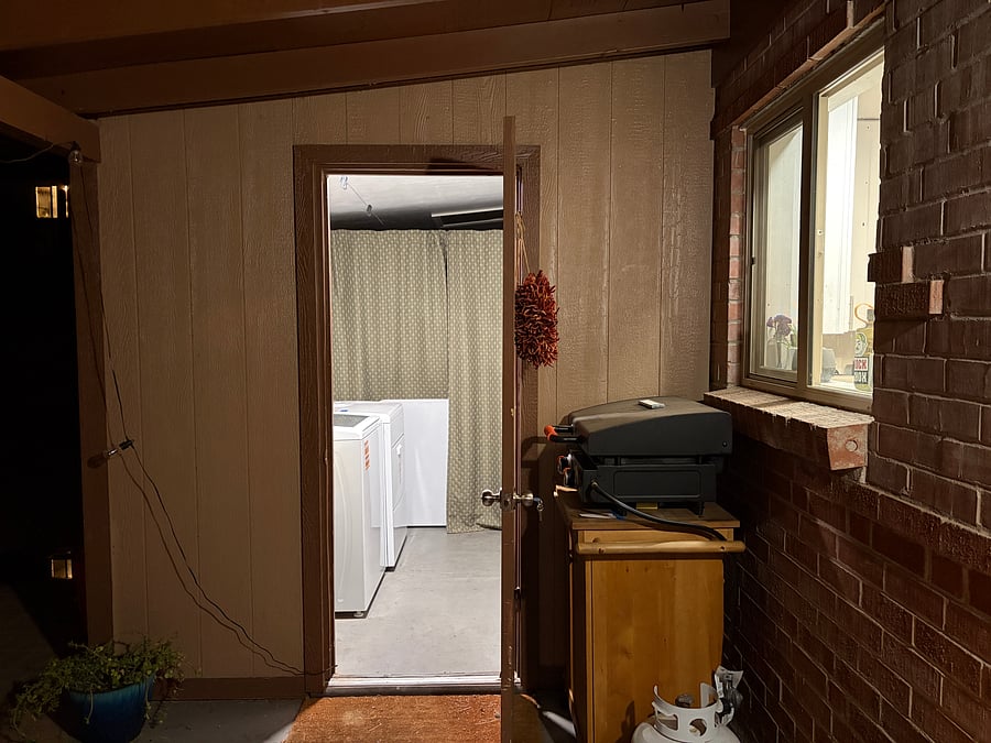 The entrance to the laundry room is off the covered patio right outside the sliding doors off the dining area. For reference, this window here is the kitchen window.