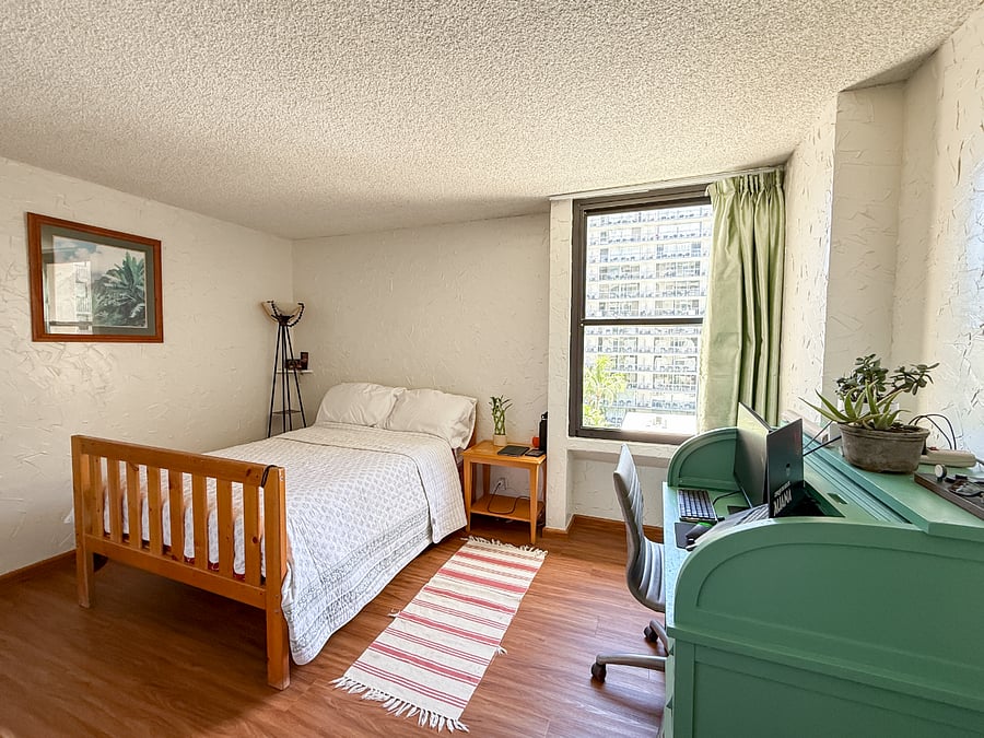 The bedroom for rent comes with a full size bed, linens, pillows, desk / chair, lamp, and a bedside table, and has a similar view as the view from the living room.