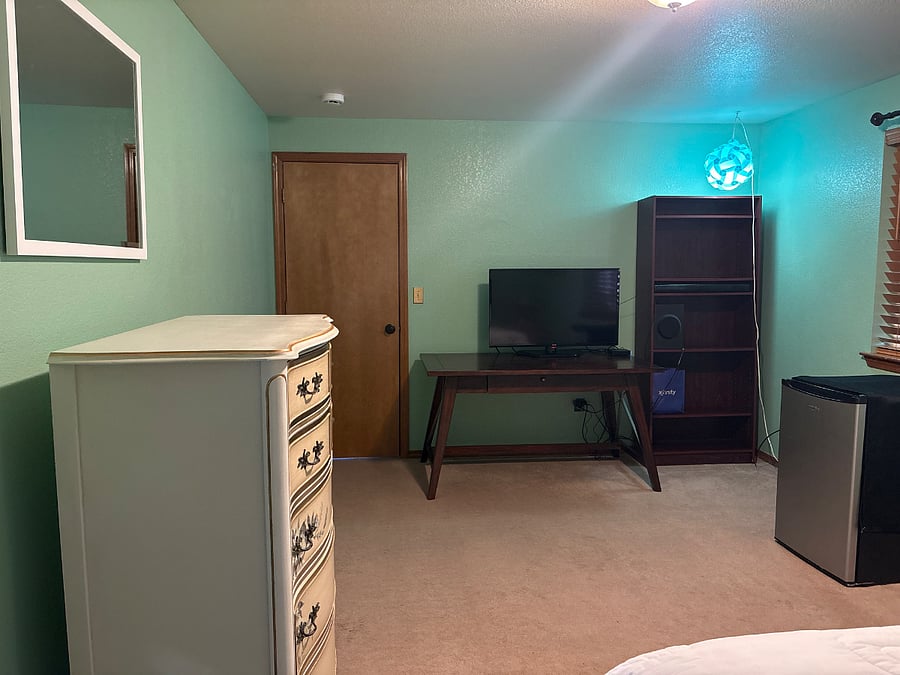 Antique dresser with mirror and desk with with TV and also a storage bookcase and refrigerator, And also lock with keys door