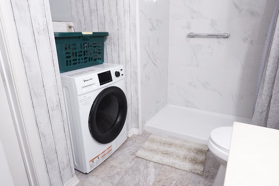 In-unit dual washer and dryer conveniently located in the bathroom for easy laundry access.