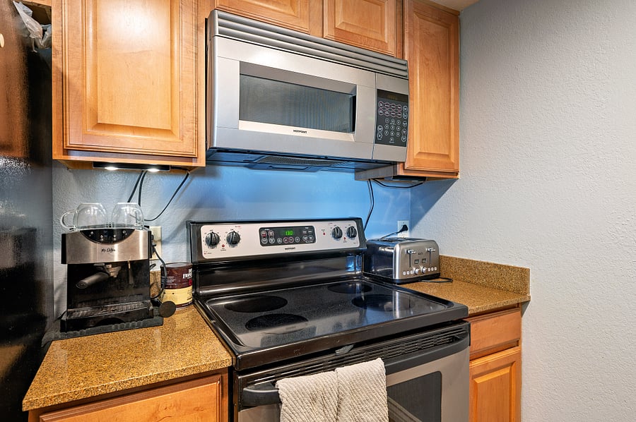 Kitchen. Microwave, oven, dishwasher, cookware, utensils, and dinnerware.