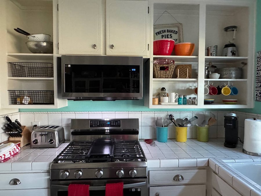 Bright kitchen with gas stove, microwave, Keurig, toaster, open shelving, and dishwasher. Includes cookware, utensils, and spiceseverything you need to cook or reheat meals during your stay
