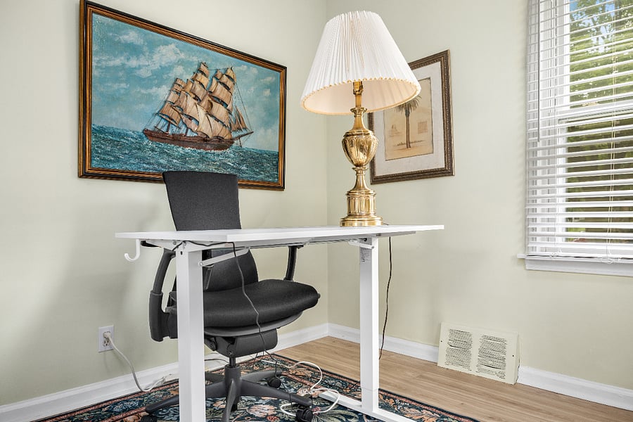 Located in Bedroom 2, ample office space with an electronic standing desk and ergonomic chair.
