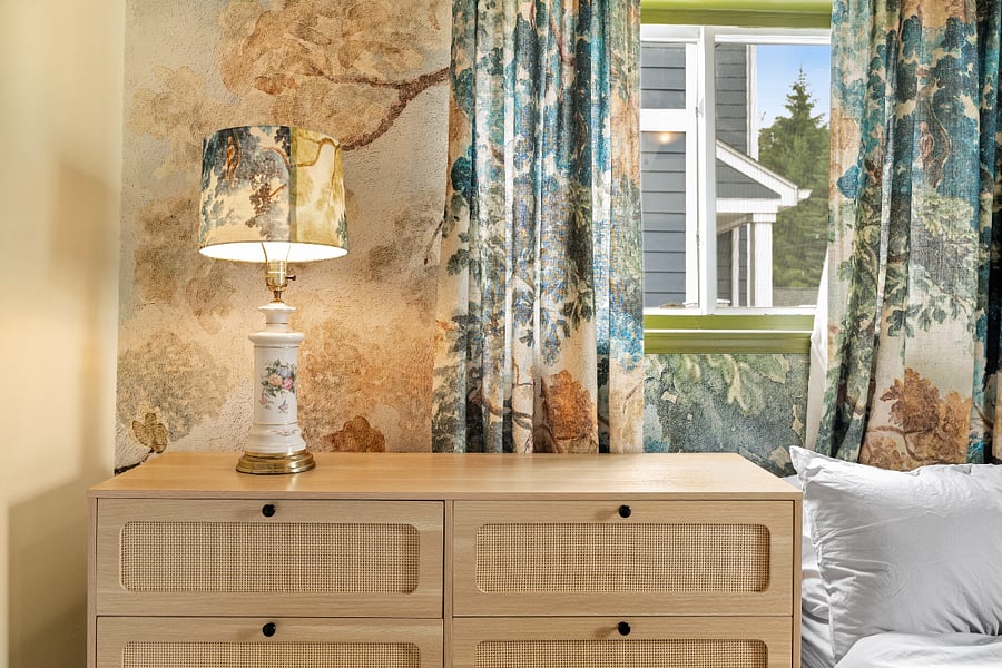 Drawers and closet space. Vintage lamp. Wall mural with matching shade and curtains.