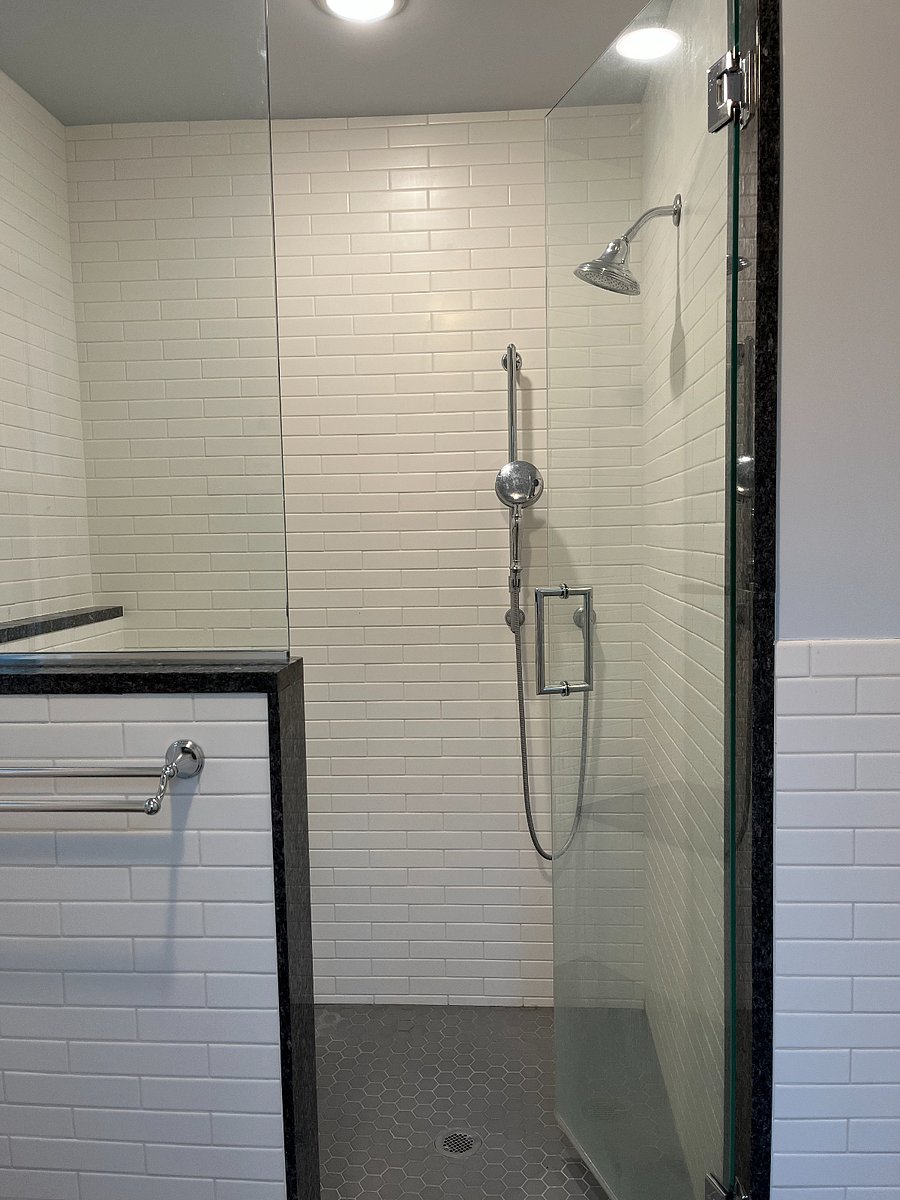Second floor bathroom walk-in shower. There is a bench, tall shower head, and handheld shower.