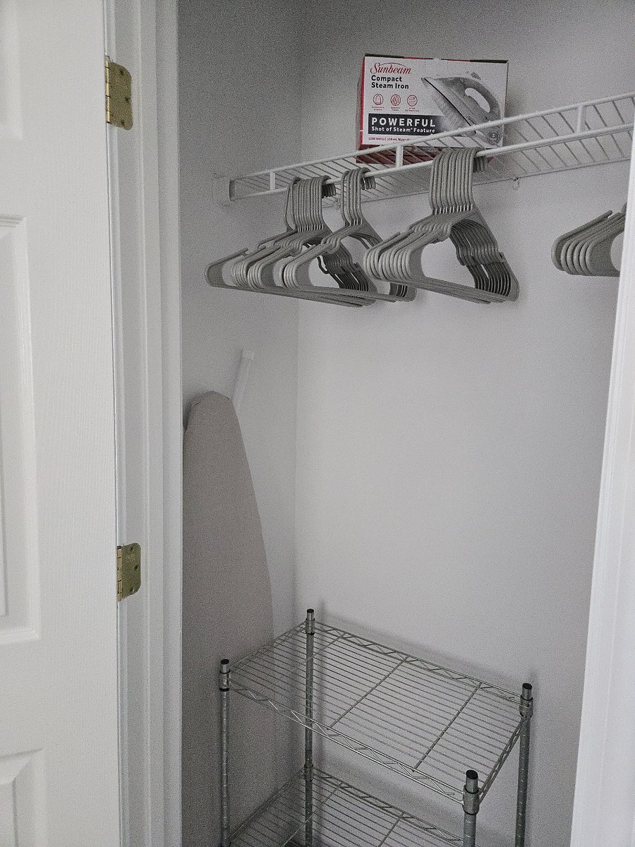 Coat/linen closet with vacuum and iron/ironing board