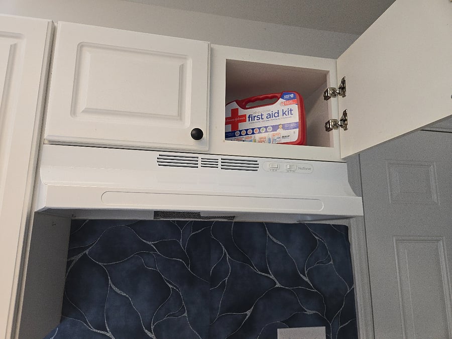 Kitchen area with stove exhaust and first aid kit