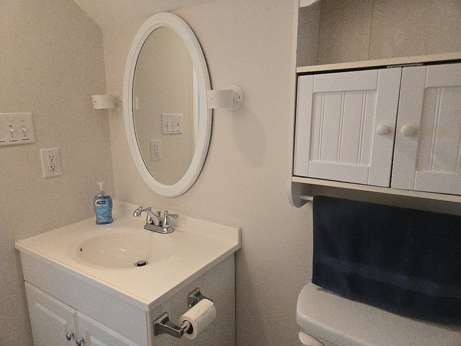 Bathroon is furnished with linens, shower curtain and clothes hamper