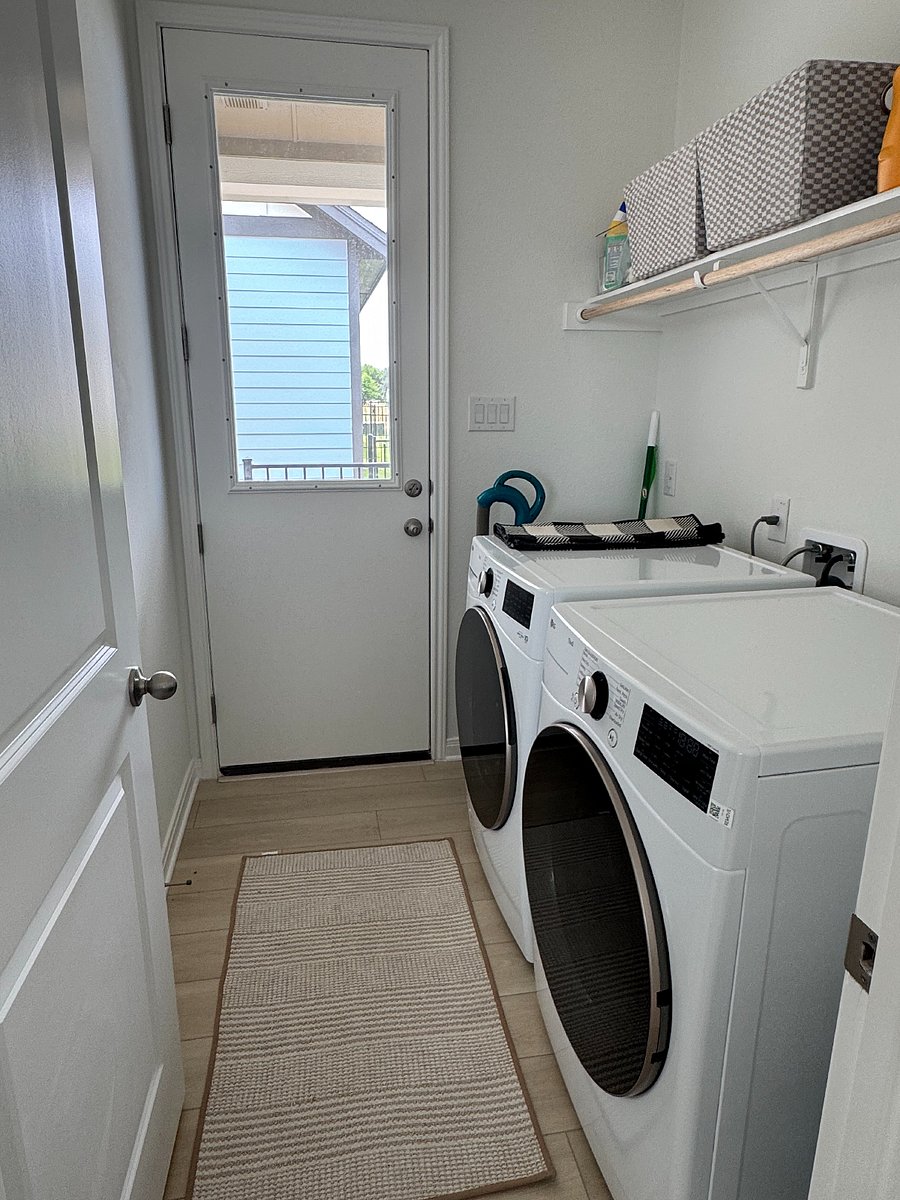 Laundry room with washer and dryer, vacuum, and cleaning products