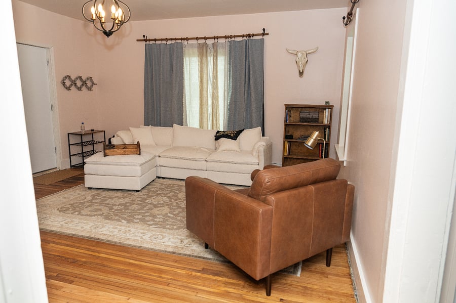 A large, comfortable couch and an oversized leather chair offer ample seating. 