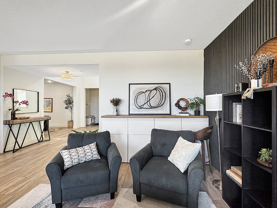 Living room featuring a grand view of the park. Furnished with extra deep couch, four comfortable sofa chairs, extra large 75" tv and tall task chair at a beautiful wood table top task area above Ikea cabinets.