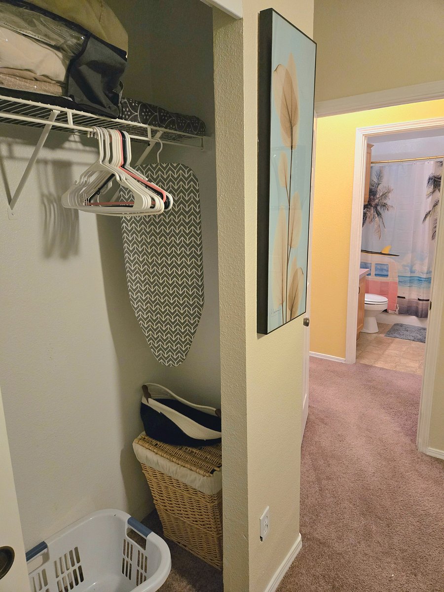 Private in-room closet with extra linens, storage, laundry basket, and hangers. Private bathroom located directly across the hall.