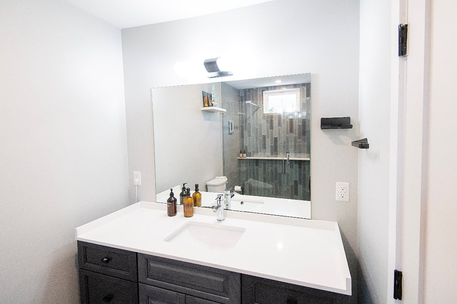The on-suite bathroom has a large glass enclosed shower with rain head and handheld sprayer - the convenient shelf holds a plethora of personal care items.