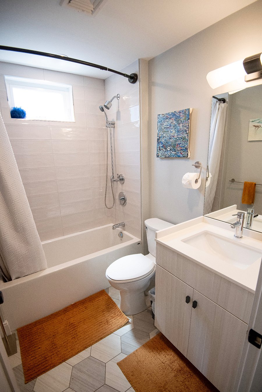 The main/guest bathroom off the living room features a deep soaker tub with shower.