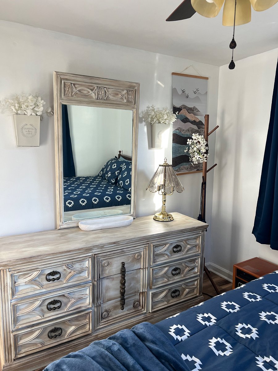 Bedroom with queen size bed. Coat rack and dresser to store clothing.