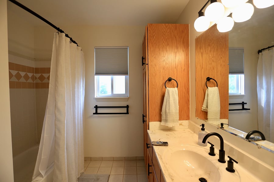 Second bathroom on upper level offers bath tub and shower